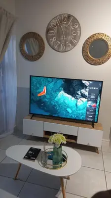 a living room with a tv and a table at The Blyde resort in Pretoria