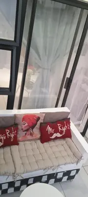 a red bird sitting on top of a couch with pillows at The Blyde resort in Pretoria