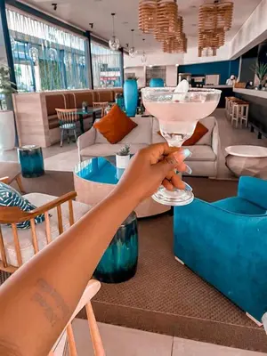 a woman holding a martini glass in a room at The Blyde resort in Pretoria