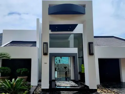 a white house with a blue roof at Hartbeespoort Lifestyle Guest House in Hartbeespoort