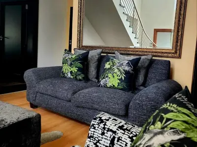 a blue couch in a living room with a mirror at Hartbeespoort Lifestyle Guest House in Hartbeespoort