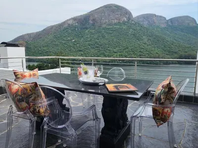a table and chairs on a balcony with a view of a mountain at Hartbeespoort Lifestyle Guest House in Hartbeespoort
