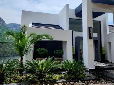 a house with palm trees in front of it at Hartbeespoort Lifestyle Guest House in Hartbeespoort