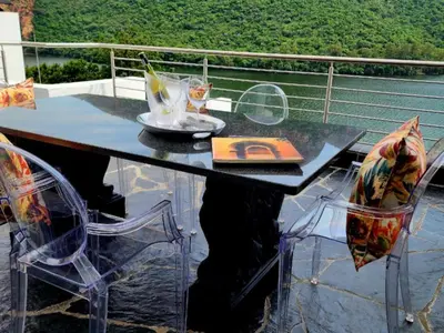a table and chairs sitting on top of a balcony at Hartbeespoort Lifestyle Guest House in Hartbeespoort