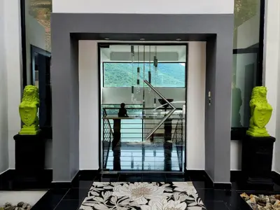 a hallway with a glass door with a person sitting at a table at Hartbeespoort Lifestyle Guest House in Hartbeespoort