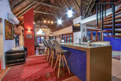 a bar with stools and a counter in a room at Lipizzaner Lodge - Kyalami, Midrand in Kyalami