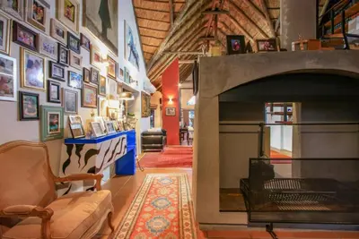 a living room with a fireplace and a couch at Lipizzaner Lodge - Kyalami, Midrand in Kyalami