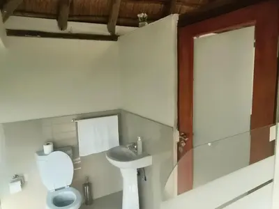 a bathroom with a toilet and a sink at Lipizzaner Lodge - Kyalami, Midrand in Kyalami