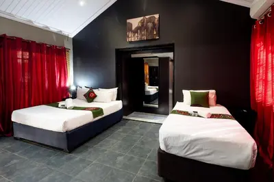 two beds in a room with red curtains at Eco Lodge Lephalale in Lephalale