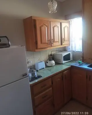 a kitchen with wooden cabinets and a white refrigerator at CHEZ BRUNO in Pretoria