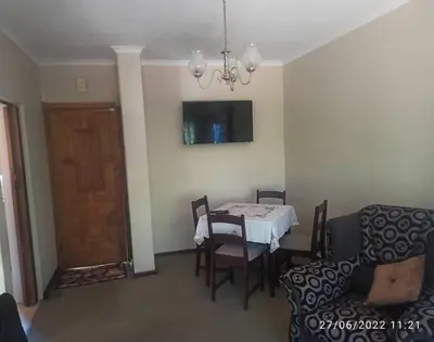 a dining room with a table and chairs and a door at CHEZ BRUNO in Pretoria