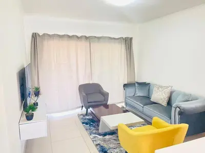 a living room with a couch and a chair at Priceless 2Bed, Pool, Gym, Wifi in Midrand