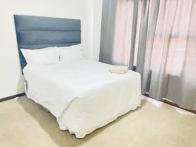a large white bed in a room with a window at Priceless 2Bed, Pool, Gym, Wifi in Midrand