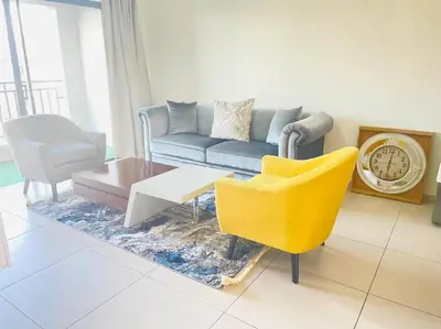a living room with a couch and a chair at Priceless 2Bed, Pool, Gym, Wifi in Midrand
