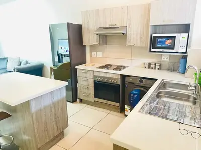 a kitchen with a sink and a stove at Priceless 2Bed, Pool, Gym, Wifi in Midrand