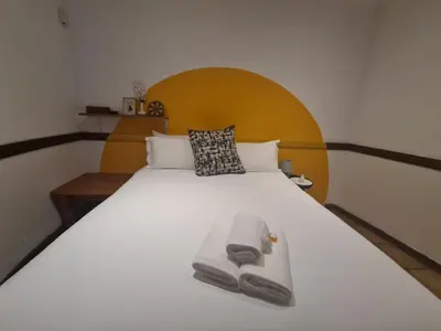 a bedroom with a large white bed with a wooden headboard at Mountain Villa House in Hartbeespoort