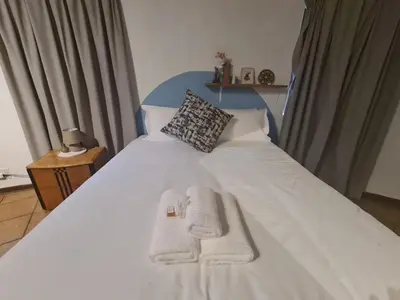 a bedroom with a white bed with towels on it at Mountain Villa House in Hartbeespoort
