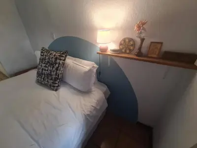 a bedroom with a bed with a pillow and a shelf at Mountain Villa House in Hartbeespoort