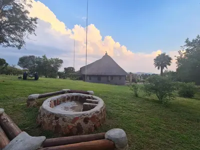 a large log in a field with a building in the background at Mountain Villa House in Hartbeespoort