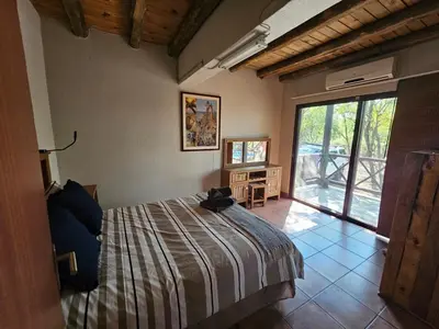 a bedroom with a bed and a large window at Amani Milele (Everlasting Peace) in Marloth Park