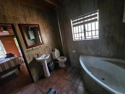 a bathroom with a tub and a toilet and a sink at Amani Milele (Everlasting Peace) in Marloth Park