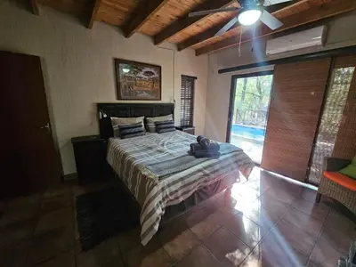 a bedroom with a bed and a large window at Amani Milele (Everlasting Peace) in Marloth Park