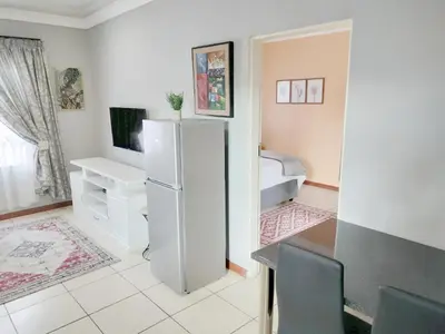 a kitchen with a white refrigerator in a room at Sunrise Guesthouse in Pretoria