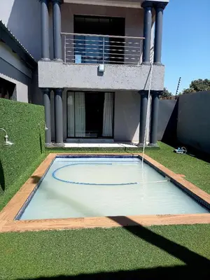 a swimming pool in the yard of a house at R&R GUEST HOUSE in Lenyenye