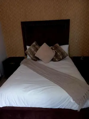 a bed with white sheets and pillows on it at R&R GUEST HOUSE in Lenyenye
