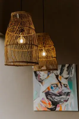 two lights hanging from the ceiling with a painting at Afri Villa Stays - Luxury Bush Villa Hyena in Marloth Park