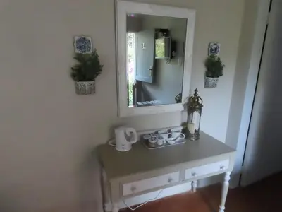 a dressing table with a mirror on a wall at Blue Bell Guesthouse in Tzaneen