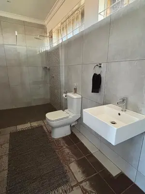 a bathroom with a white toilet and a sink at Dewdrop Farm Stay in Ermelo