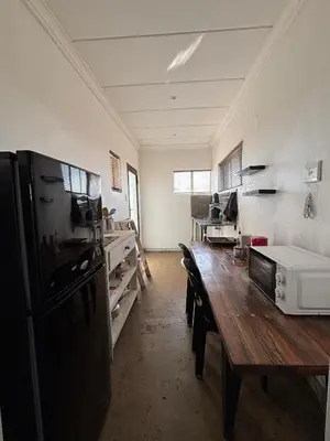 a kitchen with a wooden table and a refrigerator at Dewdrop Farm Stay in Ermelo