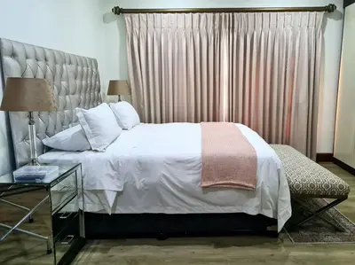 a bedroom with a large bed and a window at Spacious Golf & Wildlife Estate in Hartbeespoort 10 sleeper in Hartbeespoort