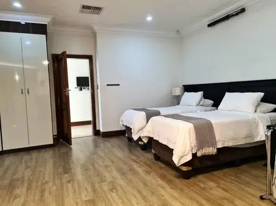 a bedroom with two beds and a door to a bathroom at Spacious Golf & Wildlife Estate in Hartbeespoort 10 sleeper in Hartbeespoort
