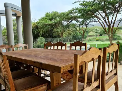 a wooden table and chairs on a porch at Spacious Golf & Wildlife Estate in Hartbeespoort 10 sleeper in Hartbeespoort