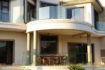 a building with a balcony with a table and chairs at Spacious Golf & Wildlife Estate in Hartbeespoort 10 sleeper in Hartbeespoort