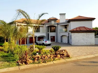 a house with a car parked in front of it at Spacious Golf & Wildlife Estate in Hartbeespoort 10 sleeper in Hartbeespoort
