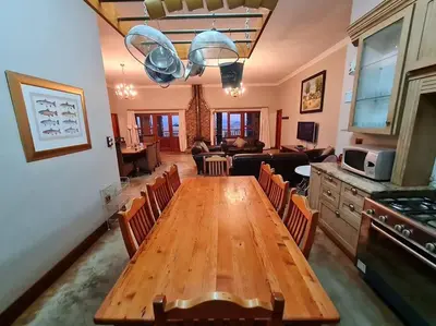a dining room and living room with a wooden table at Stone Castle, Dullstroom Country Estate in Dullstroom