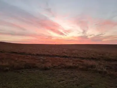 an open field with a sunset in the sky at Stone Castle, Dullstroom Country Estate in Dullstroom