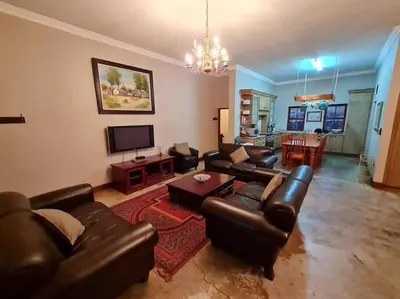 a living room with leather couches and a television at Stone Castle, Dullstroom Country Estate in Dullstroom