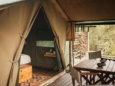 a tent with a table and a chair in it at Bushveld Bivouac Private Camp in Mica
