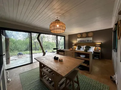 a dining room with a table and a large window at Bushveld Bivouac Private Camp in Mica