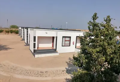 a white building with a tree in front of it at Drakensview guesthouse in Acornhoek