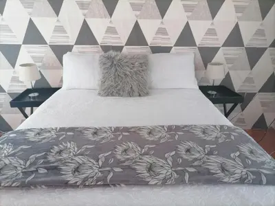 a bedroom with a bed with a flower patterned wall at Drakensview guesthouse in Acornhoek