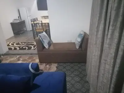 a living room with a brown couch with blue pillows at Drakensview guesthouse in Acornhoek