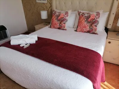 a bedroom with a large bed with a red blanket at Drakensview guesthouse in Acornhoek