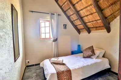 a bedroom with a bed in a room with a window at Kruger Escape - Solar System in Marloth Park