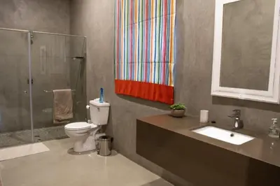 a bathroom with a toilet and a shower and a sink at The Barnhouse in Hammanskraal