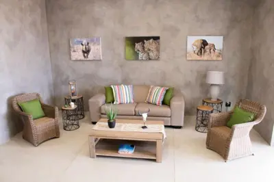 a living room with a couch and two chairs and a table at The Barnhouse in Hammanskraal
